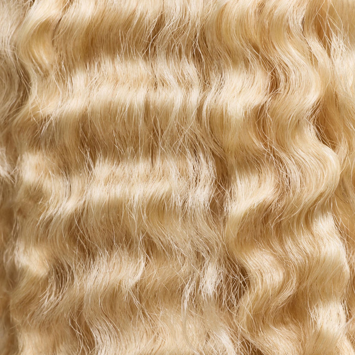 A close-up of natural curly hair extensions in a warm golden blonde shade, featuring soft, well-defined curls that add volume and bounce. These luxury textured hair extensions provide a seamless blend with natural curly hair, enhancing fullness and movement. The high-quality strands offer a lightweight, natural feel with a radiant shine, making them perfect for versatile styling and a flawless, effortless look.