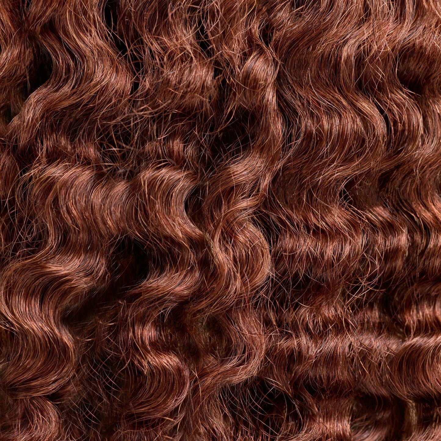 A close-up of natural curly hair extensions in a deep brown shade, featuring tight, bouncy curls that add volume and definition. These luxury textured hair extensions provide a soft, lightweight feel, designed to seamlessly blend with natural curls for a full-bodied, effortlessly stylish look. The high-quality strands offer a natural sheen and durability, making them perfect for enhancing curly hairstyles with added length and fullness.