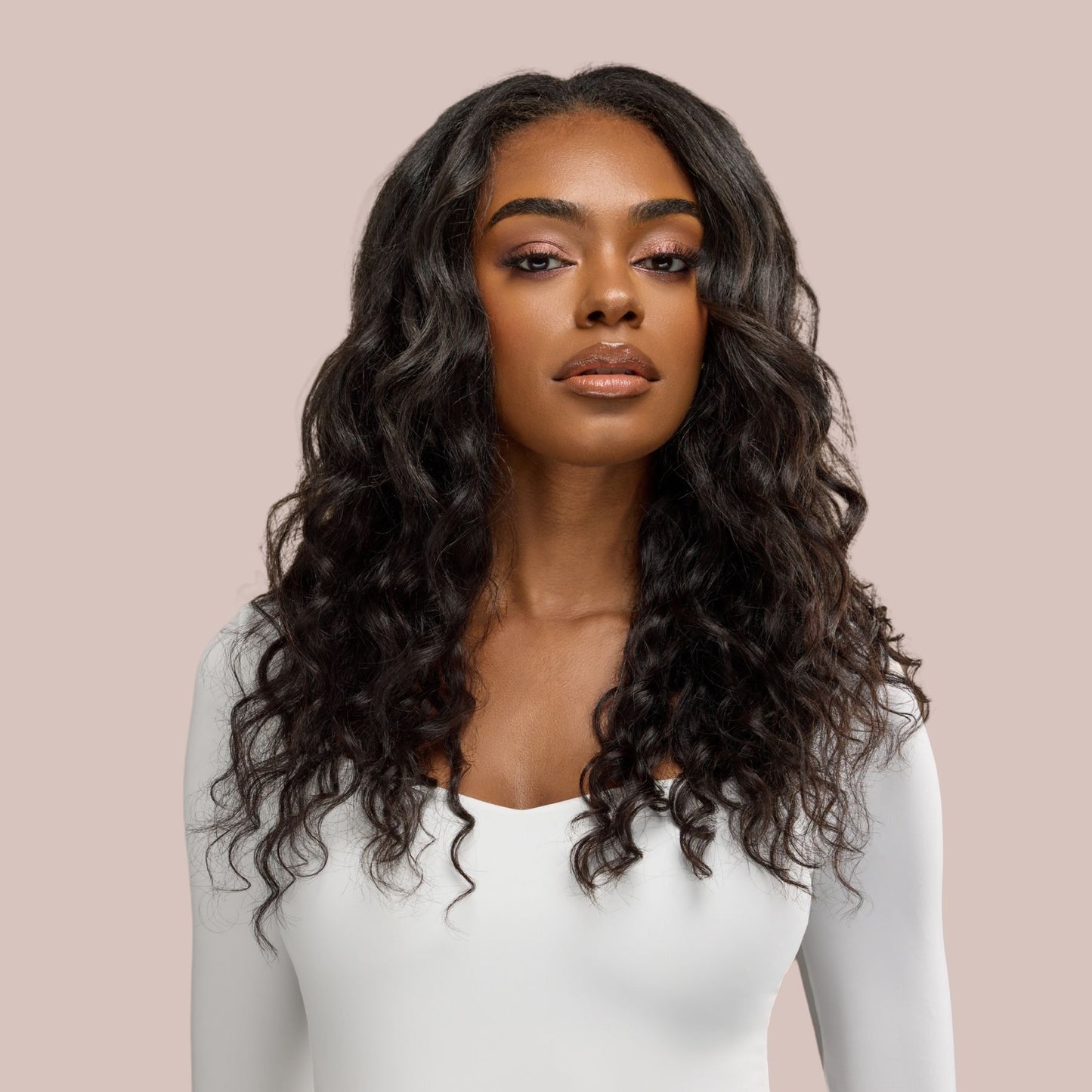 A beautiful black woman with effortlessly flowing loose wavy textured hair extensions poses with confidence, showcasing the soft, natural movement and volume of premier textured hair extensions. Her glossy, cascading waves frame her face beautifully, creating a seamless, luxurious look. The deep, defined texture of the waves enhances the natural elegance of the hairstyle, making it perfect for a sophisticated yet effortless appearance.