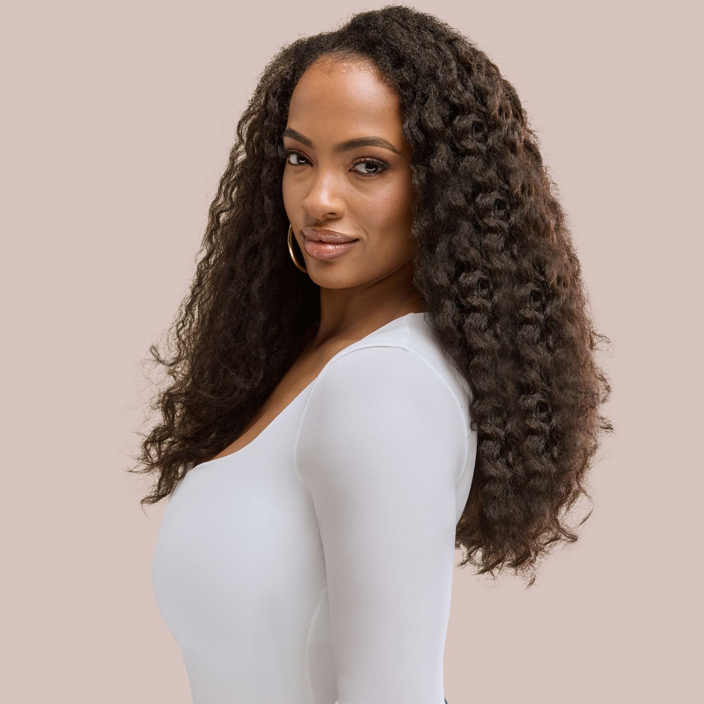 A woman with sleek, voluminous black kinky straight hair extensions, styled to enhance natural texture while providing a full-bodied, blown-out look. These textured hair extensions blend seamlessly with her natural hair, creating a soft yet thick and luxurious finish. The high-quality strands offer versatility, making them ideal for effortless styling while maintaining a natural, sophisticated appearance.