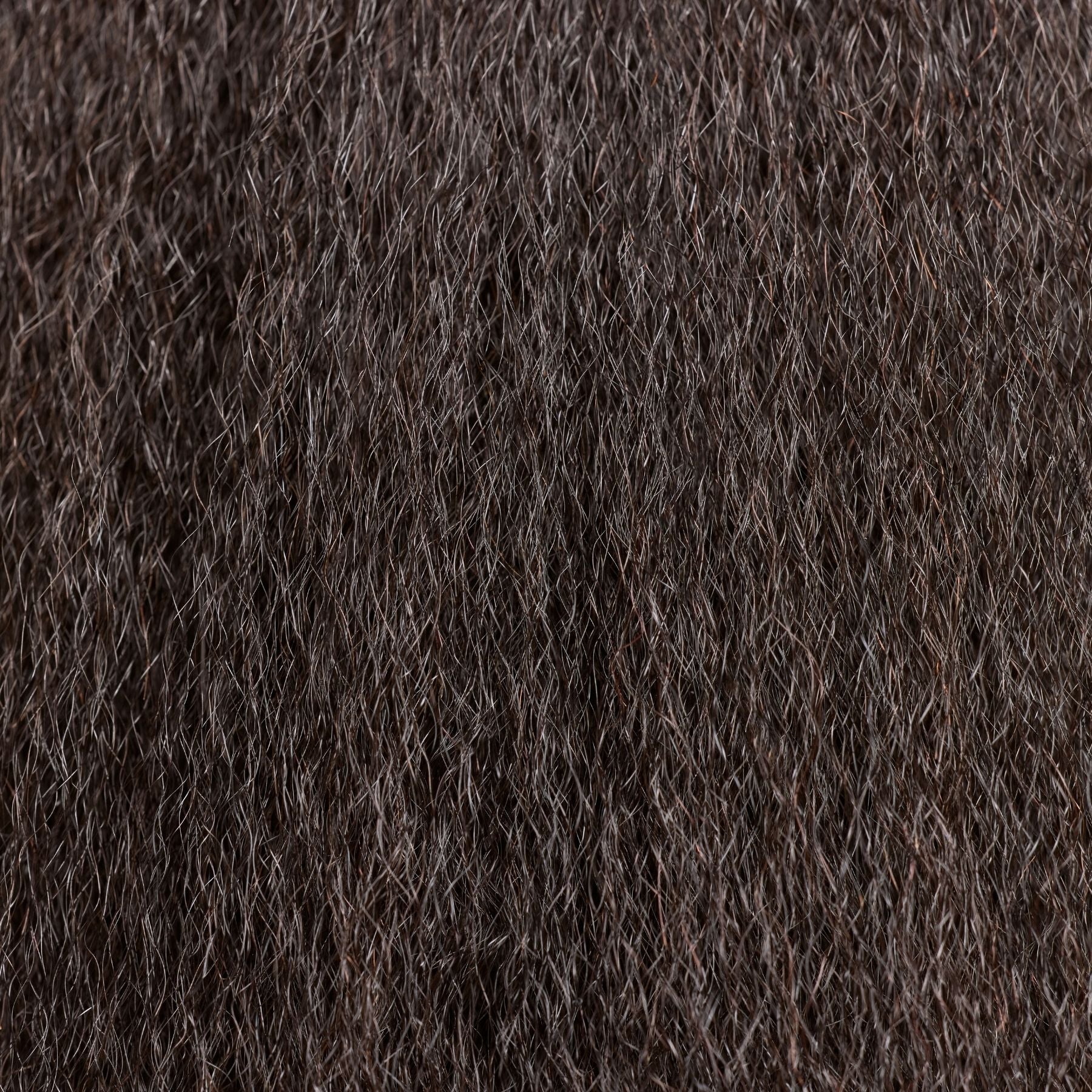 A close-up of kinky straight hair extensions in a deep natual black shade, featuring a natural, blown-out texture with soft volume and fullness. These luxury textured hair extensions are designed to blend seamlessly with coarse, natural hair, providing a thick yet lightweight feel. The high-quality strands offer versatility for styling while maintaining a smooth, realistic finish, perfect for achieving a polished and elegant look.